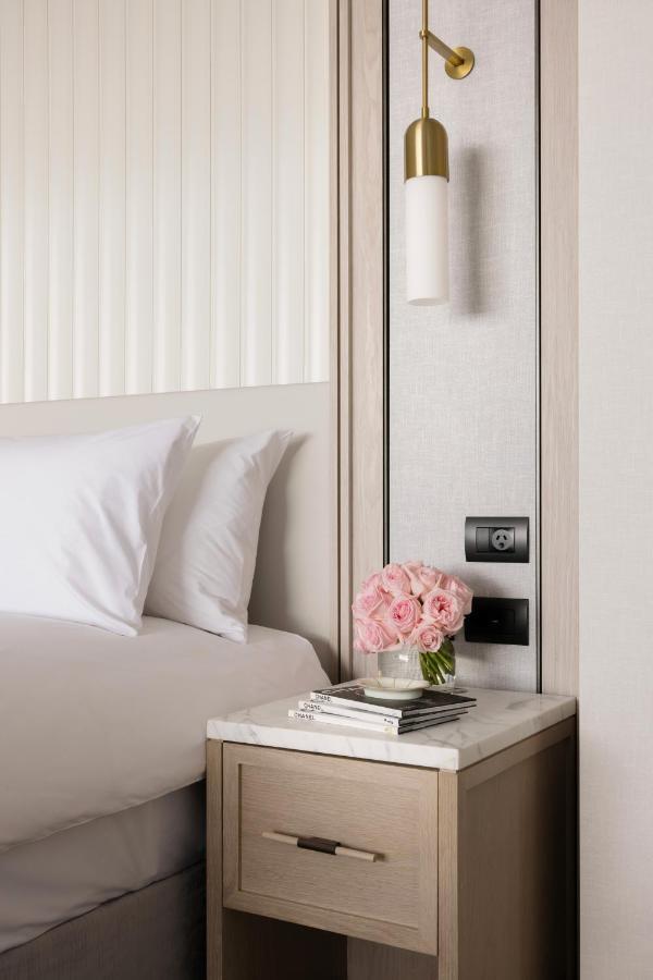 The Langham, Gold Coast And Jewel Residences 외부 사진 A bedside table with a lamp, a telephone and a vase of flowers
